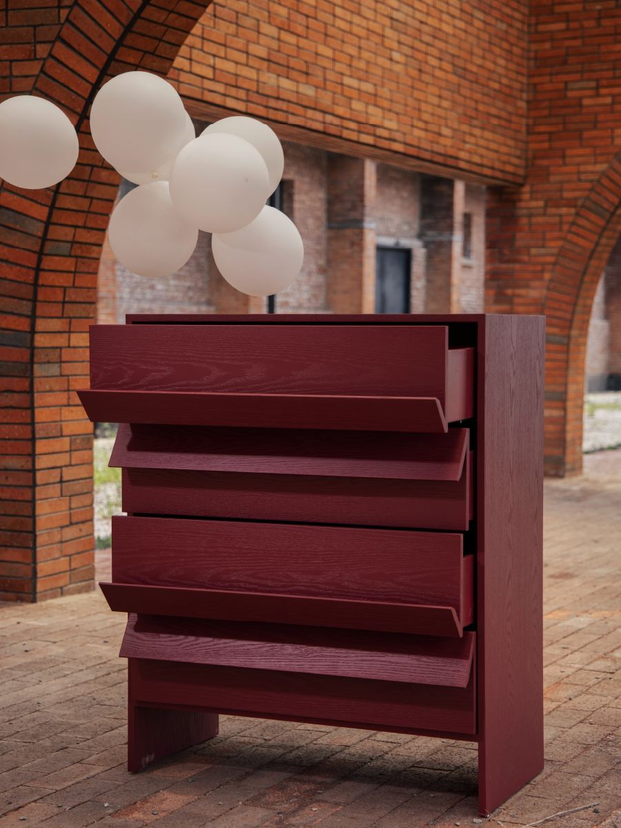 Tilt Chest in deep burgundy under brick arches